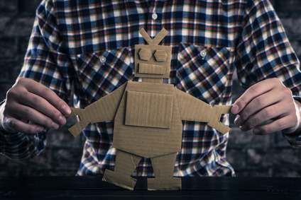 Man holding cardboard cutout of a robot