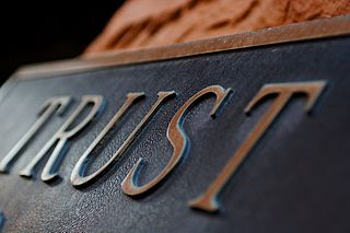 Metal plaque with the word TRUST in raised letters, originally posted to Flickr by Terry Johnston under the terms of the cc-by-2.0.