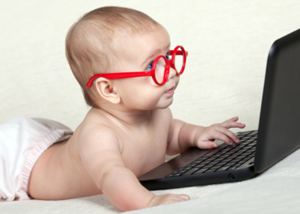 Baby wearing glasses using laptop