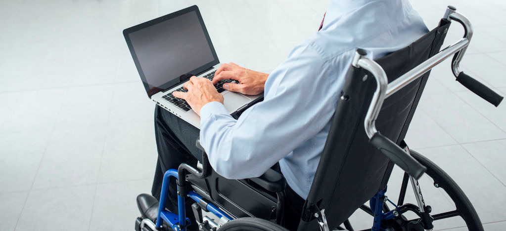 Man in wheelchair using a laptop