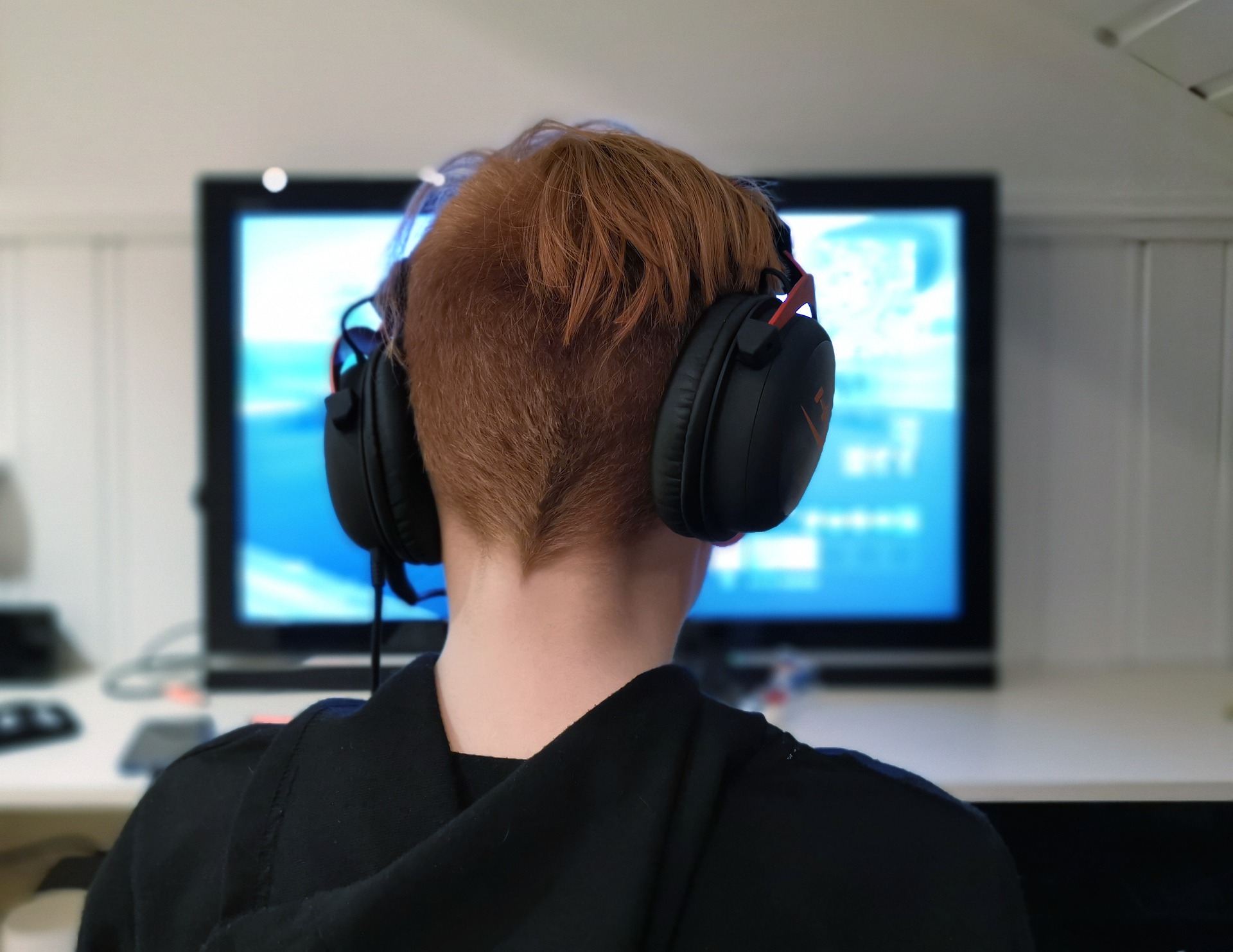 Teen with headset playing a computer game