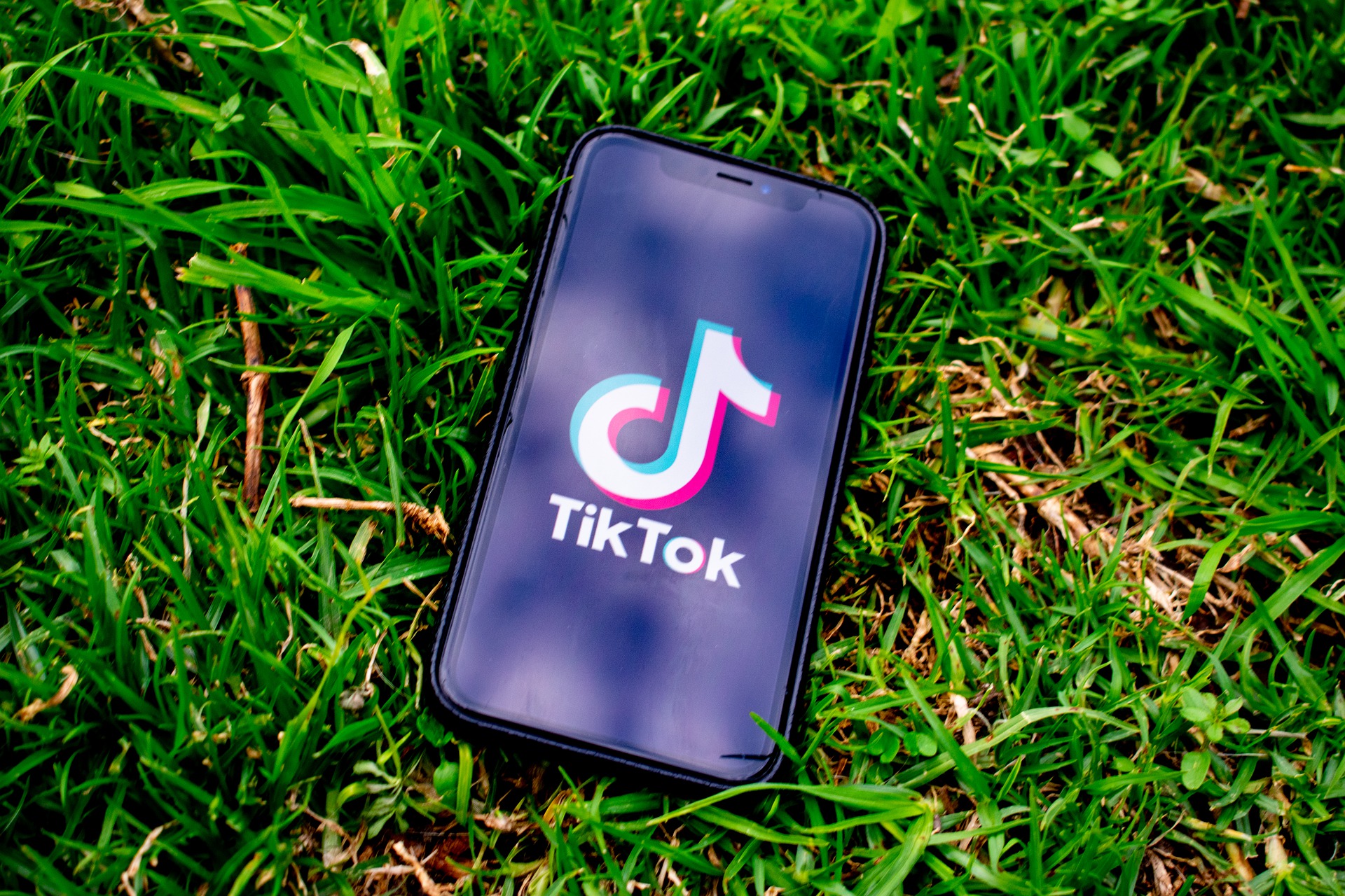Cell phone showing Tiktok on the grass