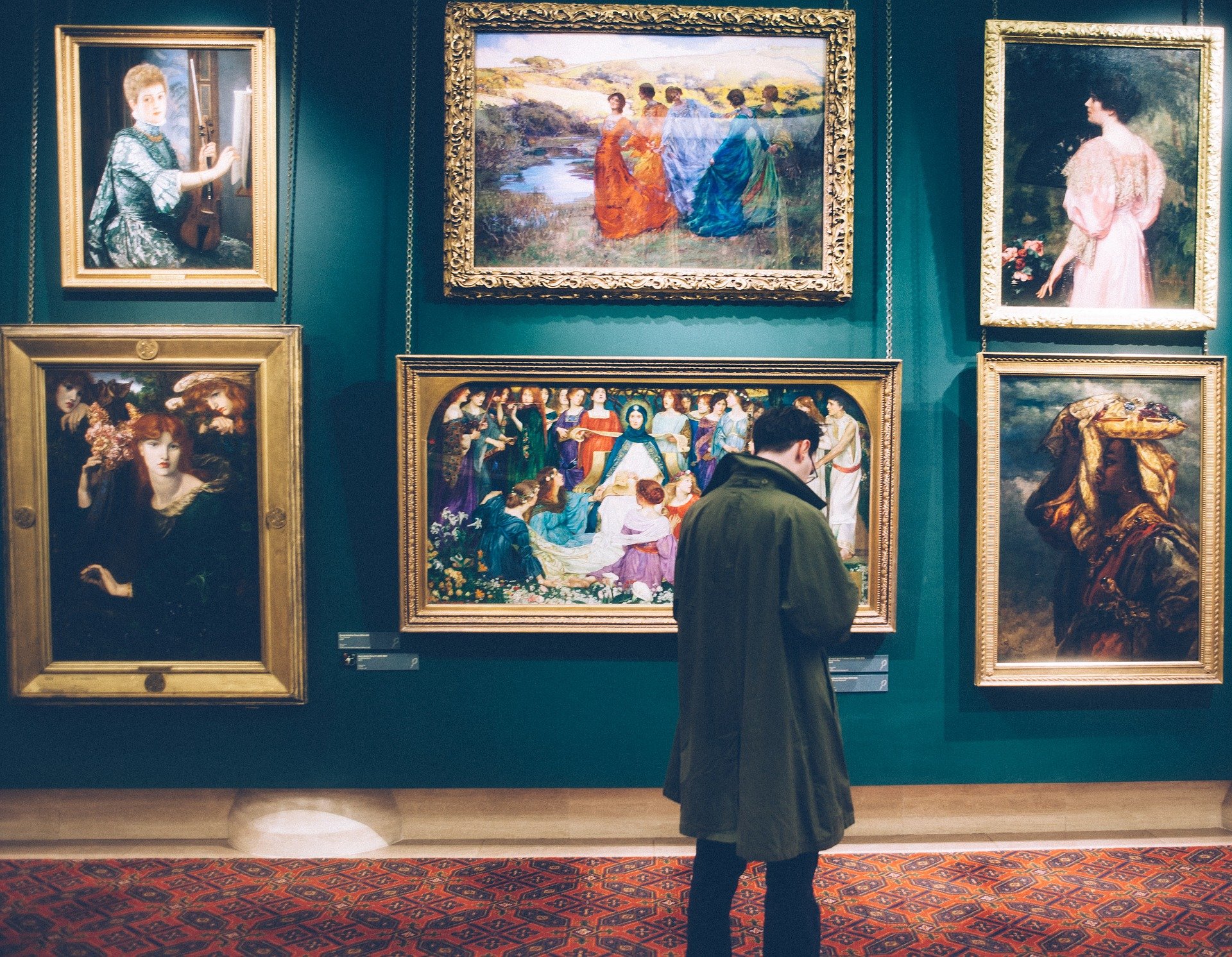 Man looking at paintings on wall of a museum