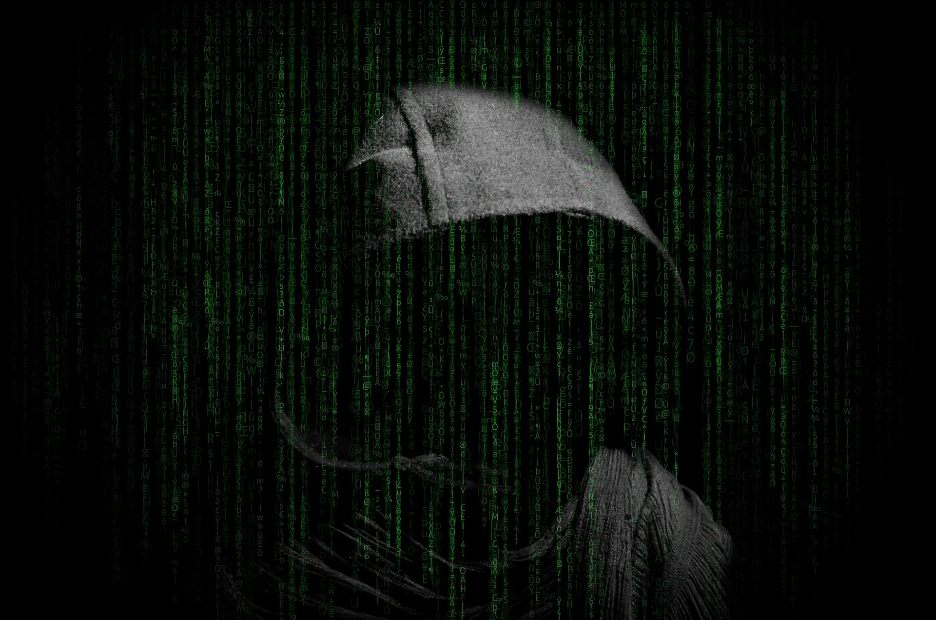 Man in dark hood with digital background