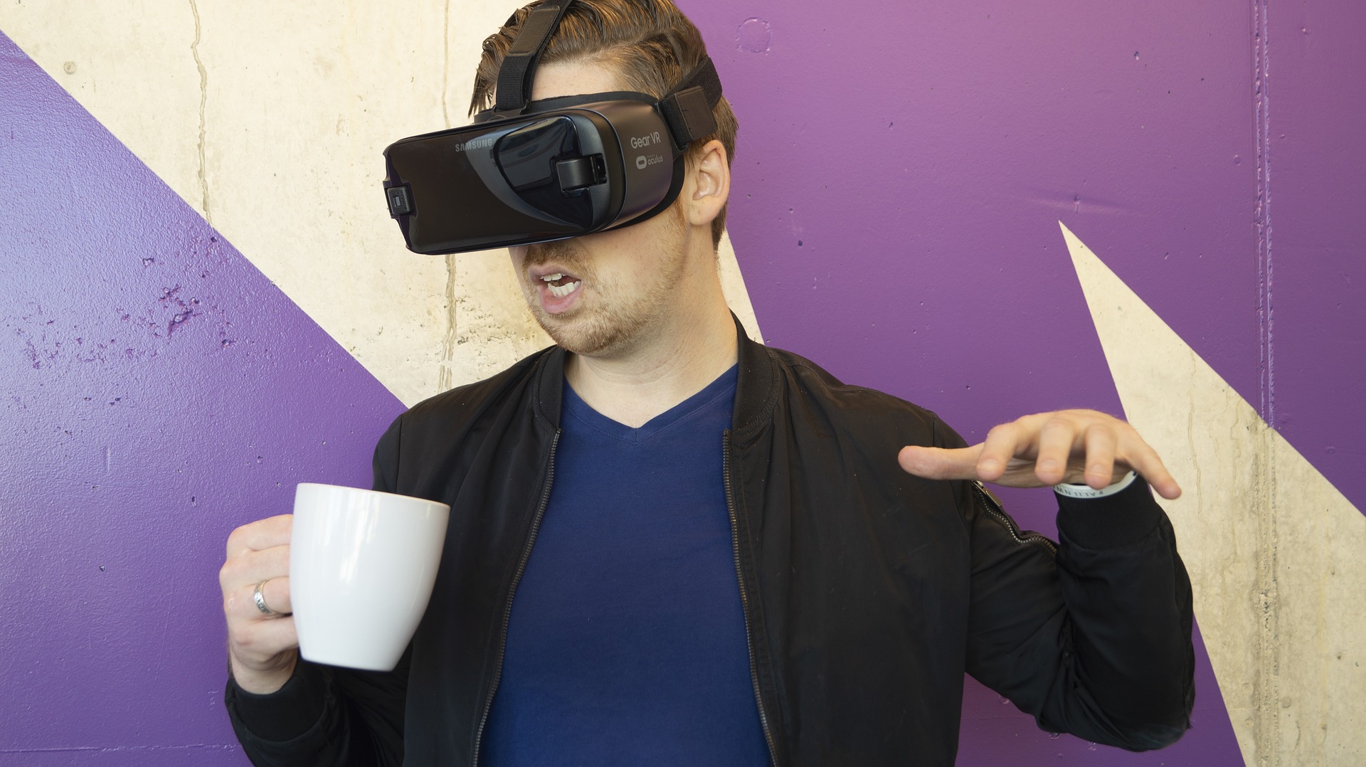 Man wearing a VR headset and holding a mug